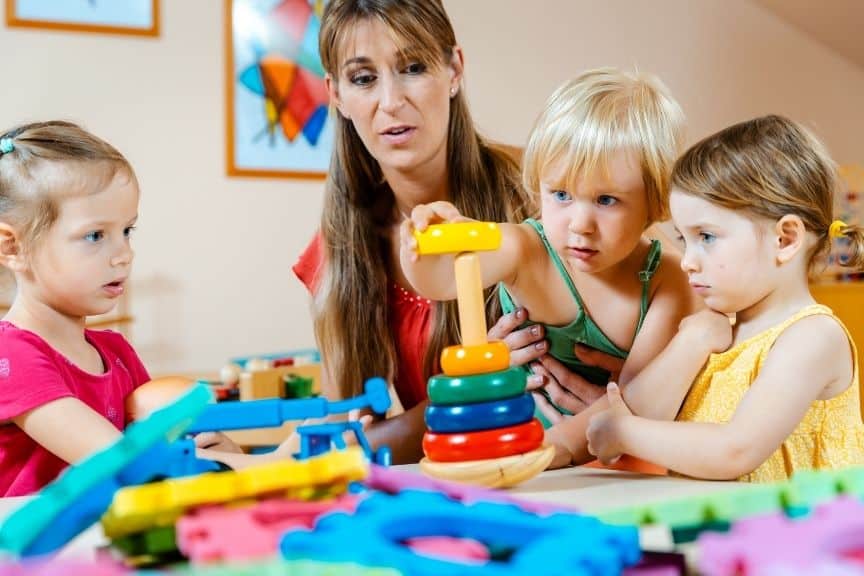 Colorful children's toys and a therapist engaging kids in play therapy session at Zuri Behavioral Therapy clinic.