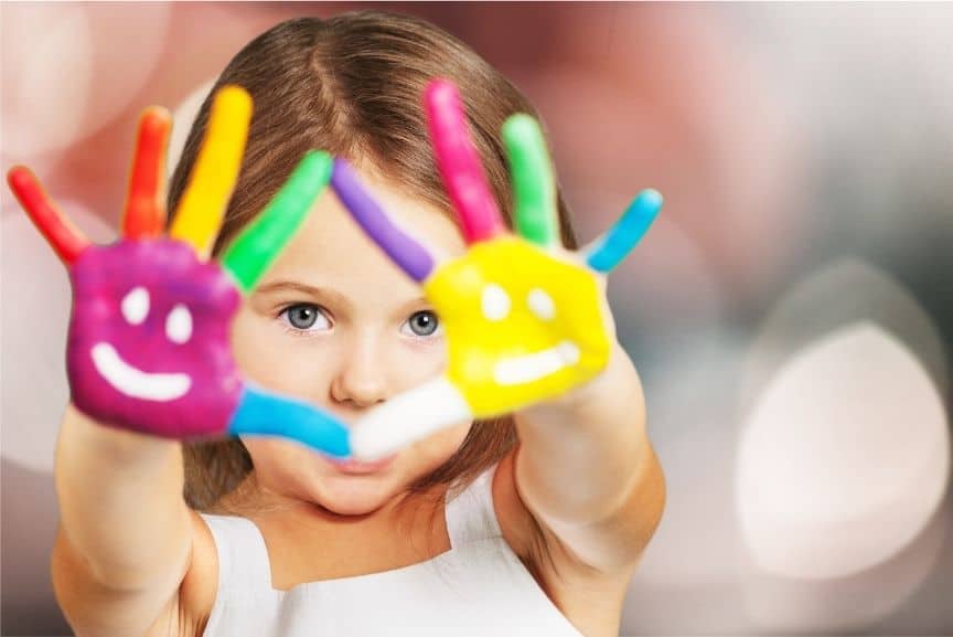 Colorful hand-painted kids' art with smiling faces, promoting creativity and emotional well-being.