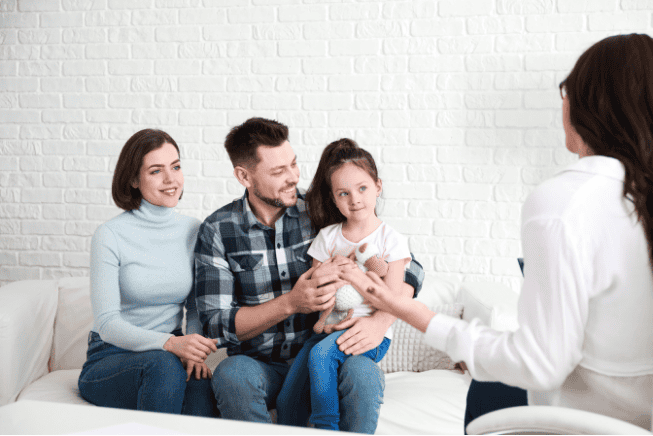 Caring therapist engaging with a family during a counseling session for emotional and behavioral support.