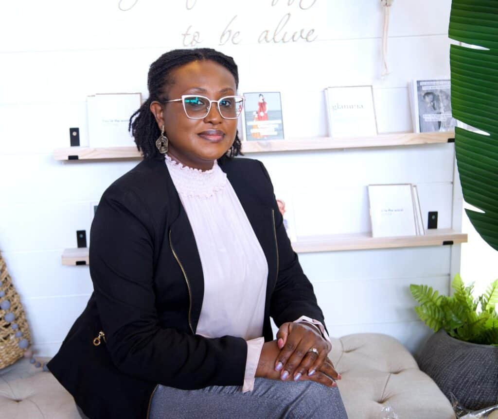 Therapist in professional attire sitting in a cozy, welcoming therapy office, promoting mental health and well-being.